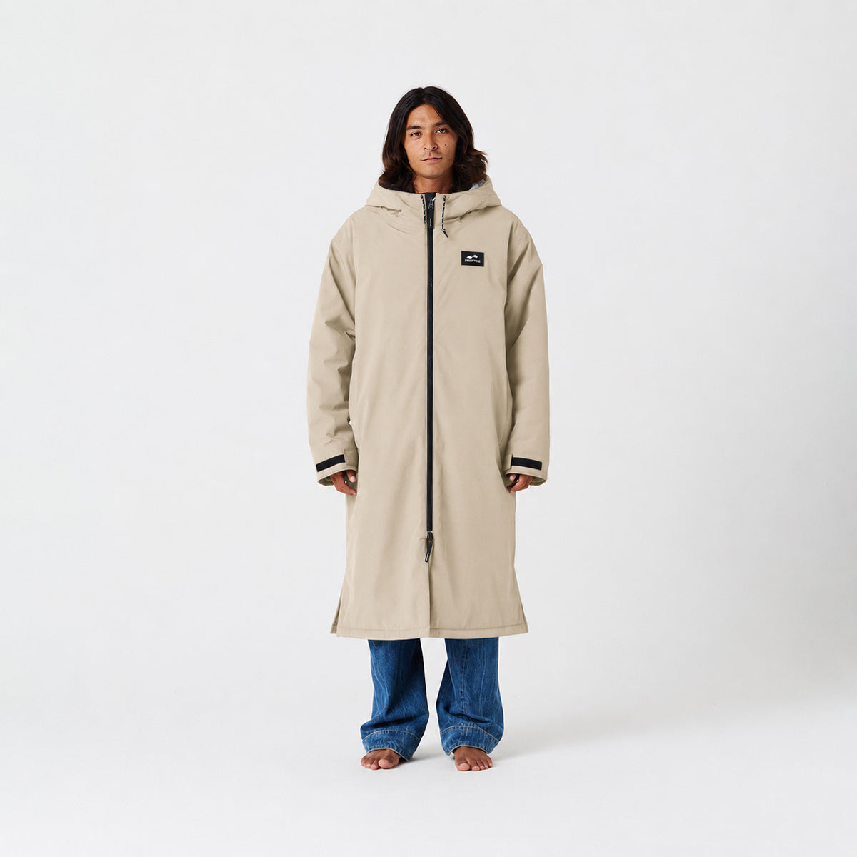 Beige long coat with blue jeans, insulated style.