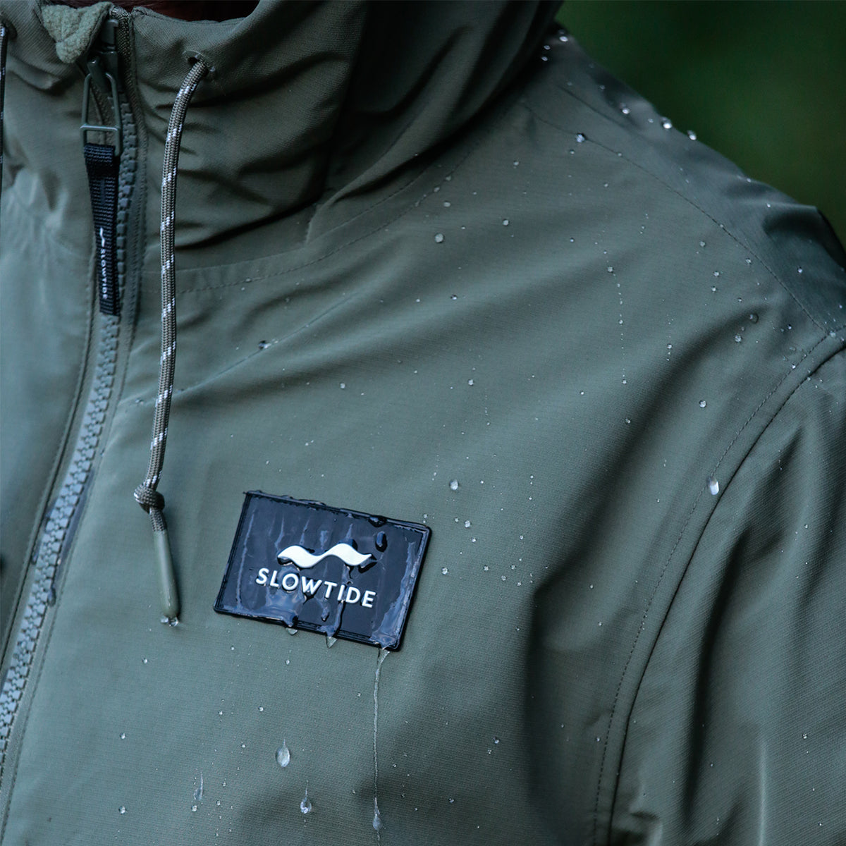 Green waterproof parka with chest patch.