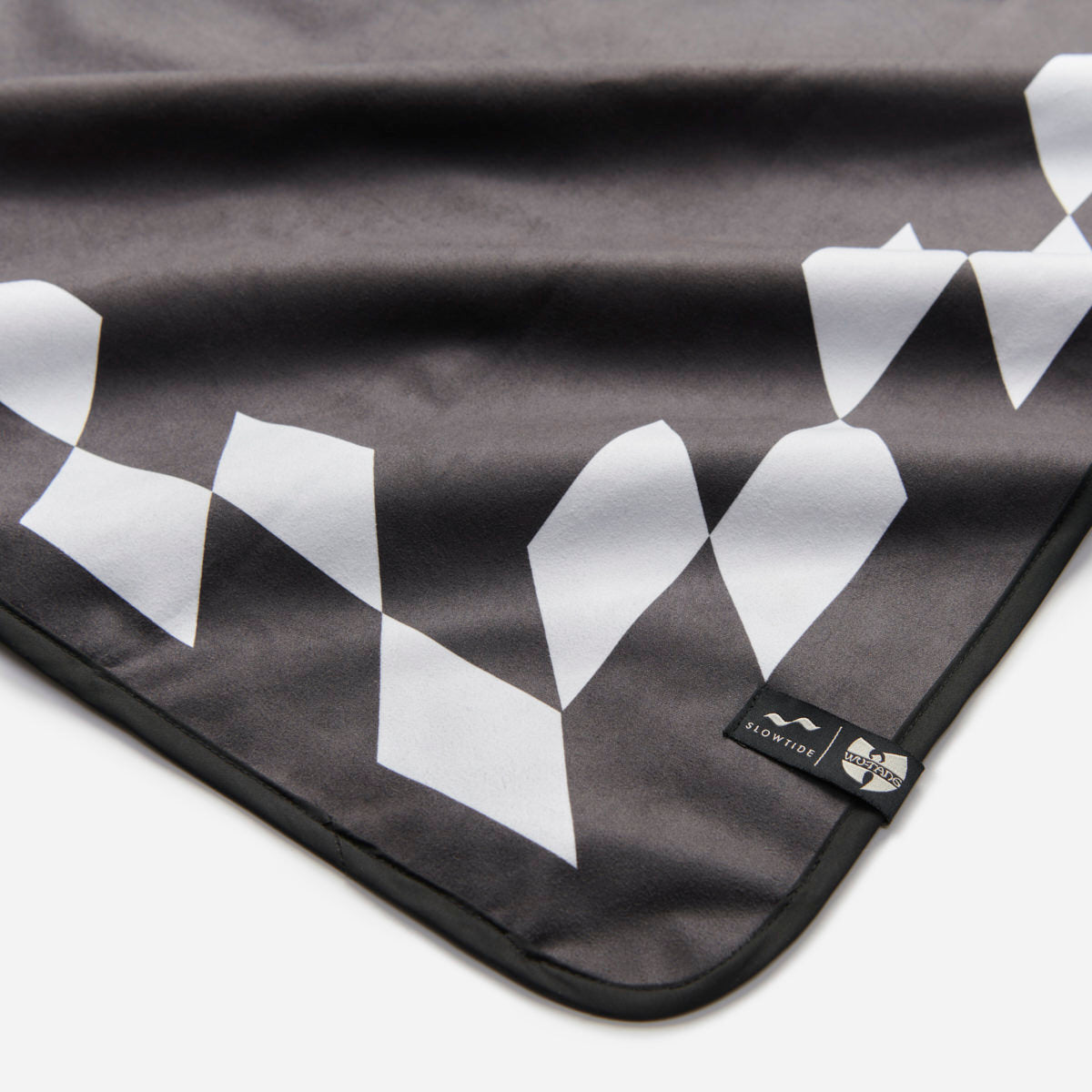 Picnic blanket, water-resistant, black and white geometric pattern with corner logo tag.