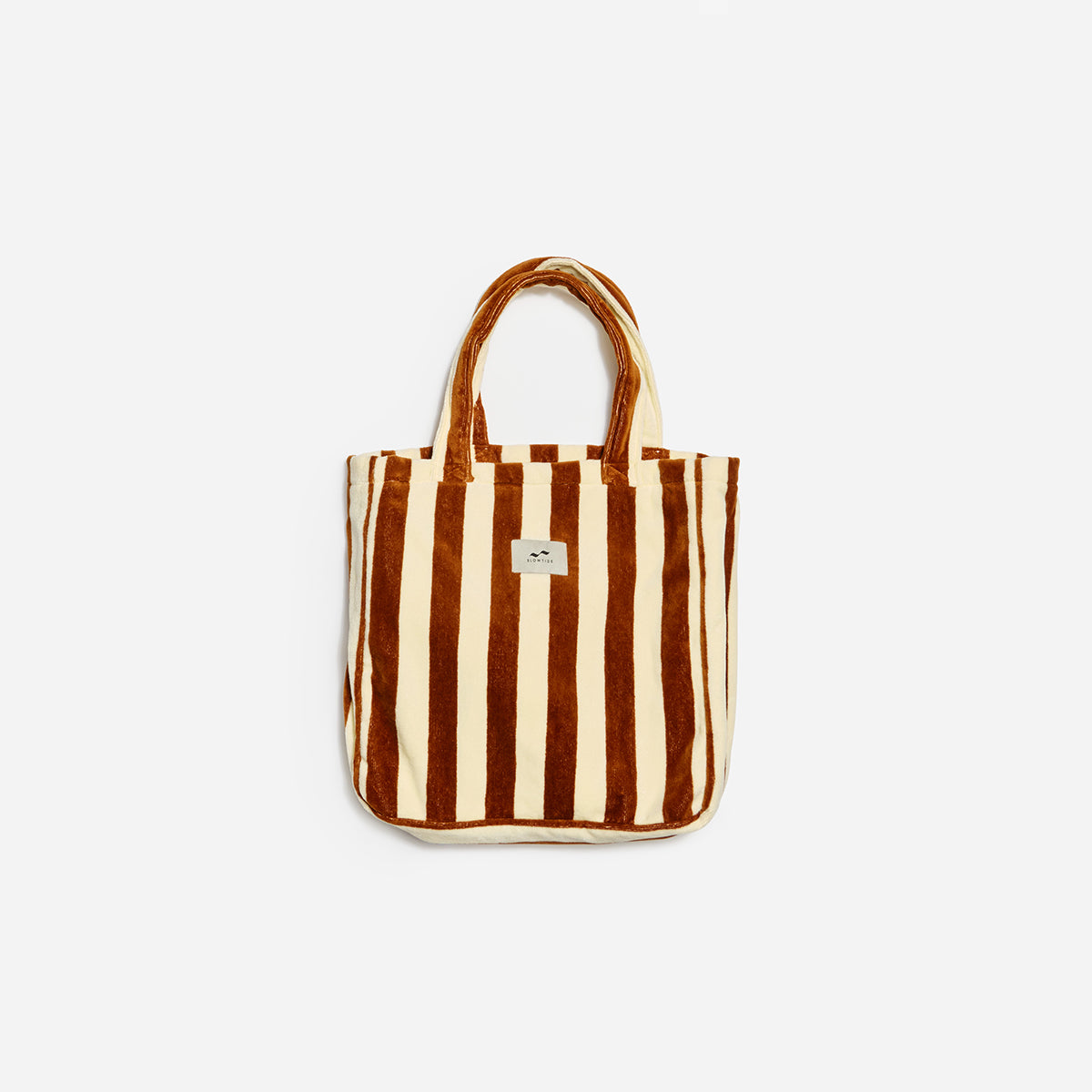 Tote bag in beige and brown terry fabric with handles and a small square logo patch.