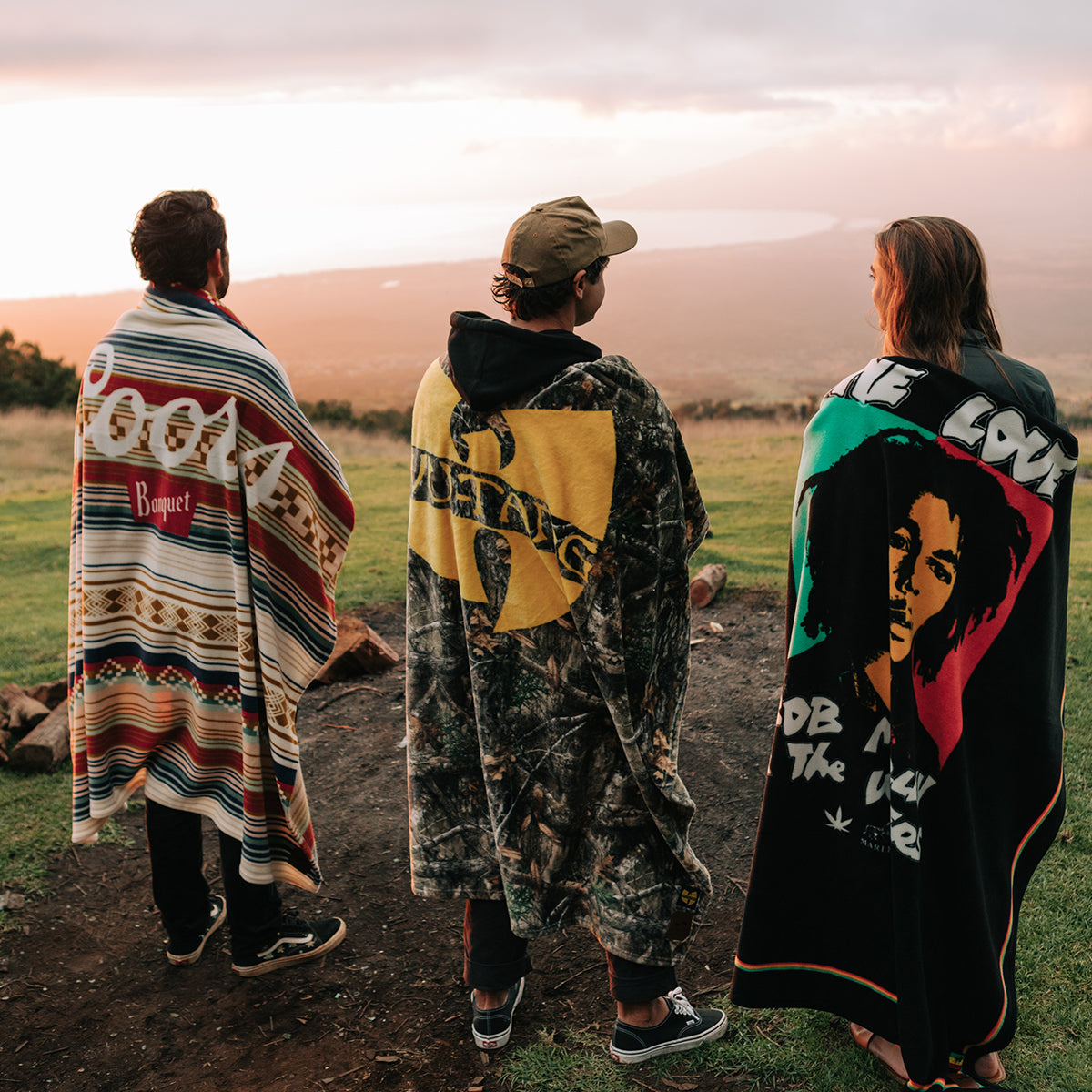 Fleece throw blankets with colorful graphic patterns outdoors.