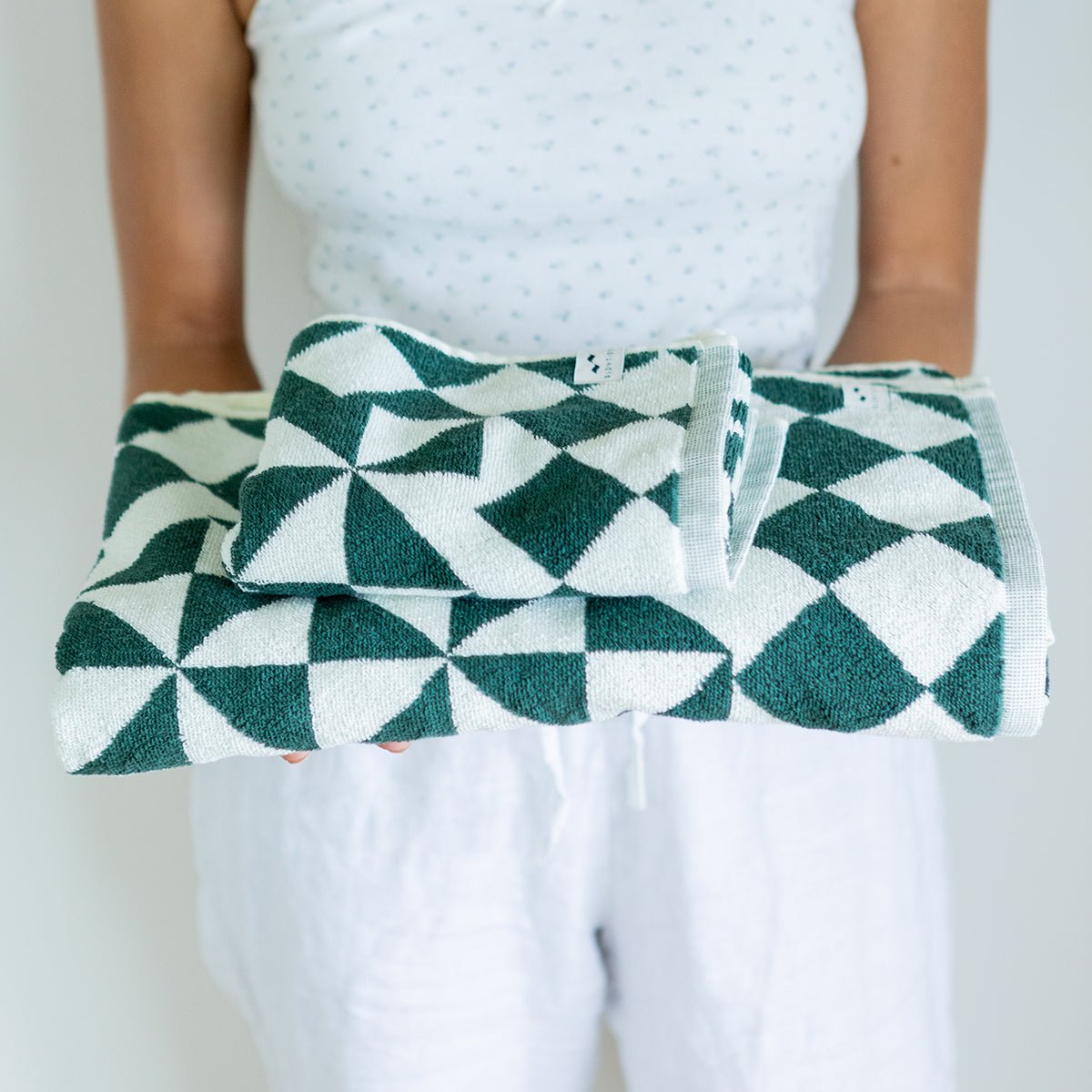 Hand towel with green and white geometric pattern, folded for display.