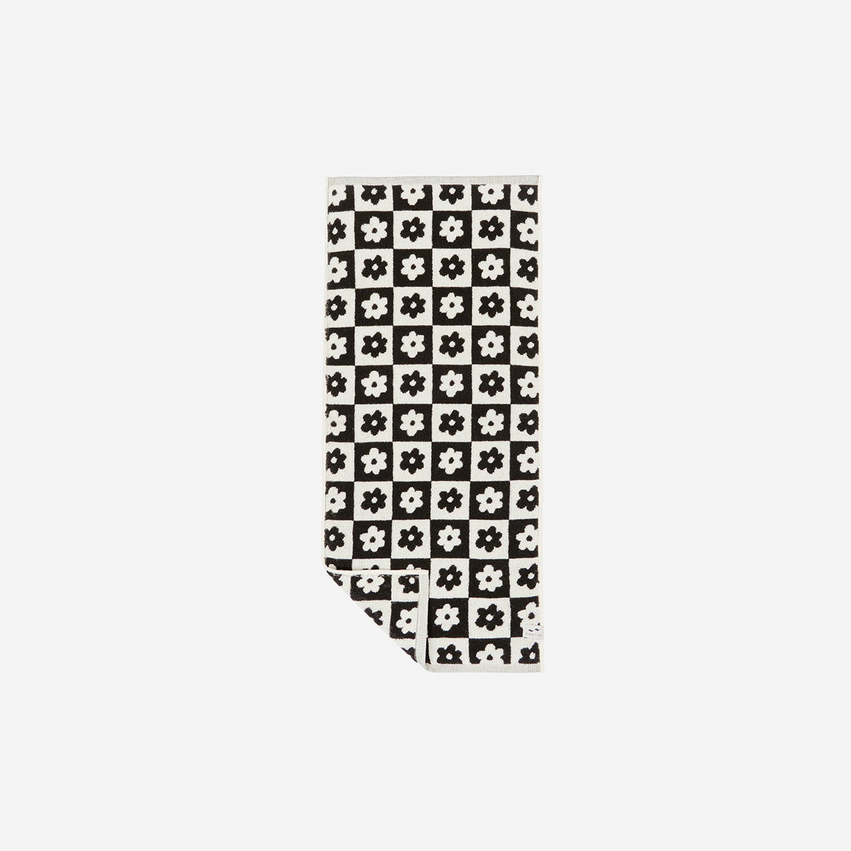 Sand resistant towel with black and white checkered floral pattern.