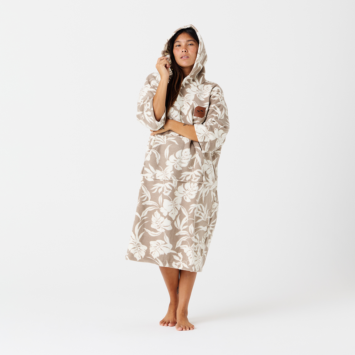 Hooded fleece poncho with beige and white floral print.