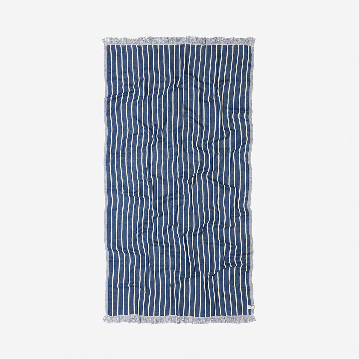 Towel with navy and white pinstripes, fringe edges, laid flat.
