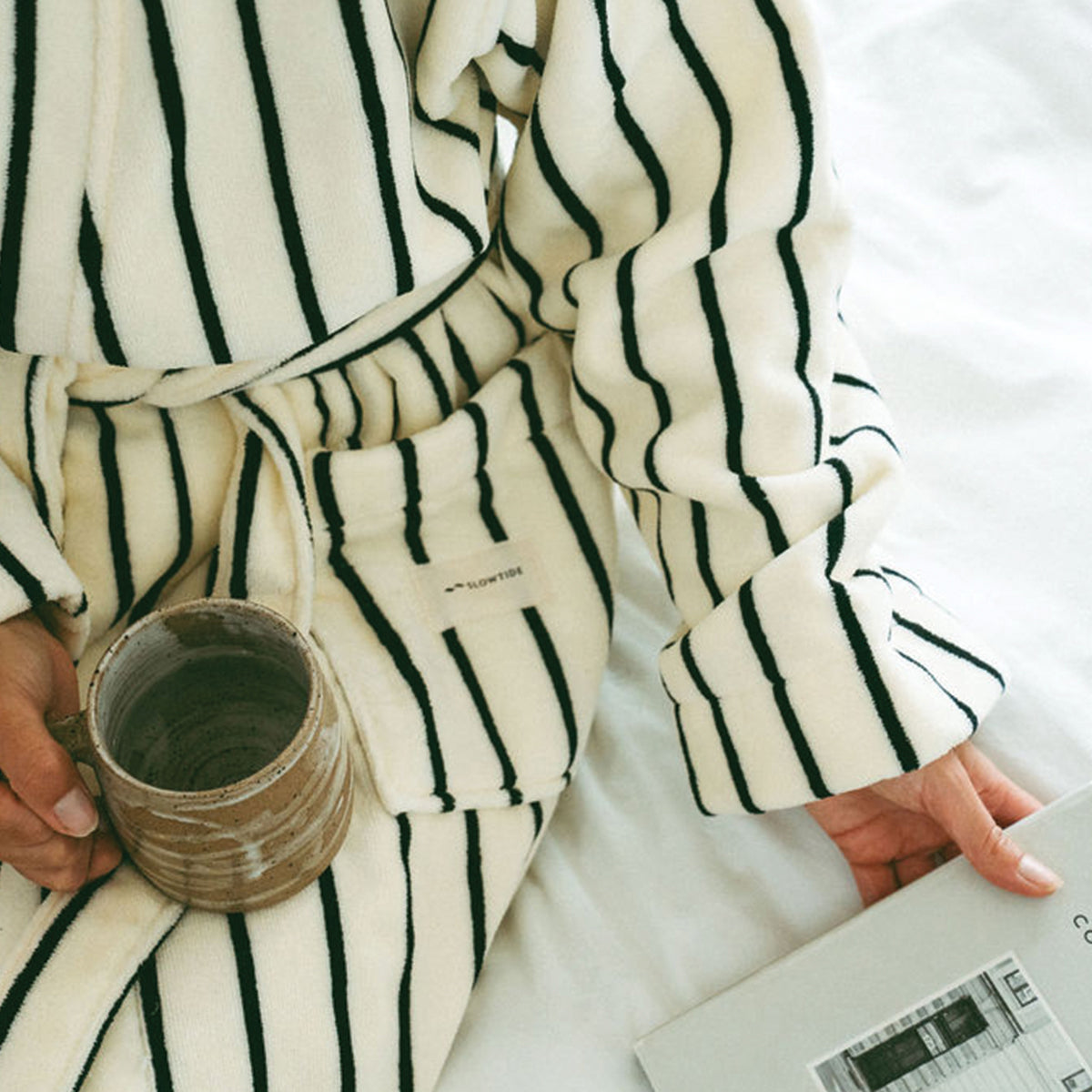 Plush bathrobe with black vertical stripes and waist tie.