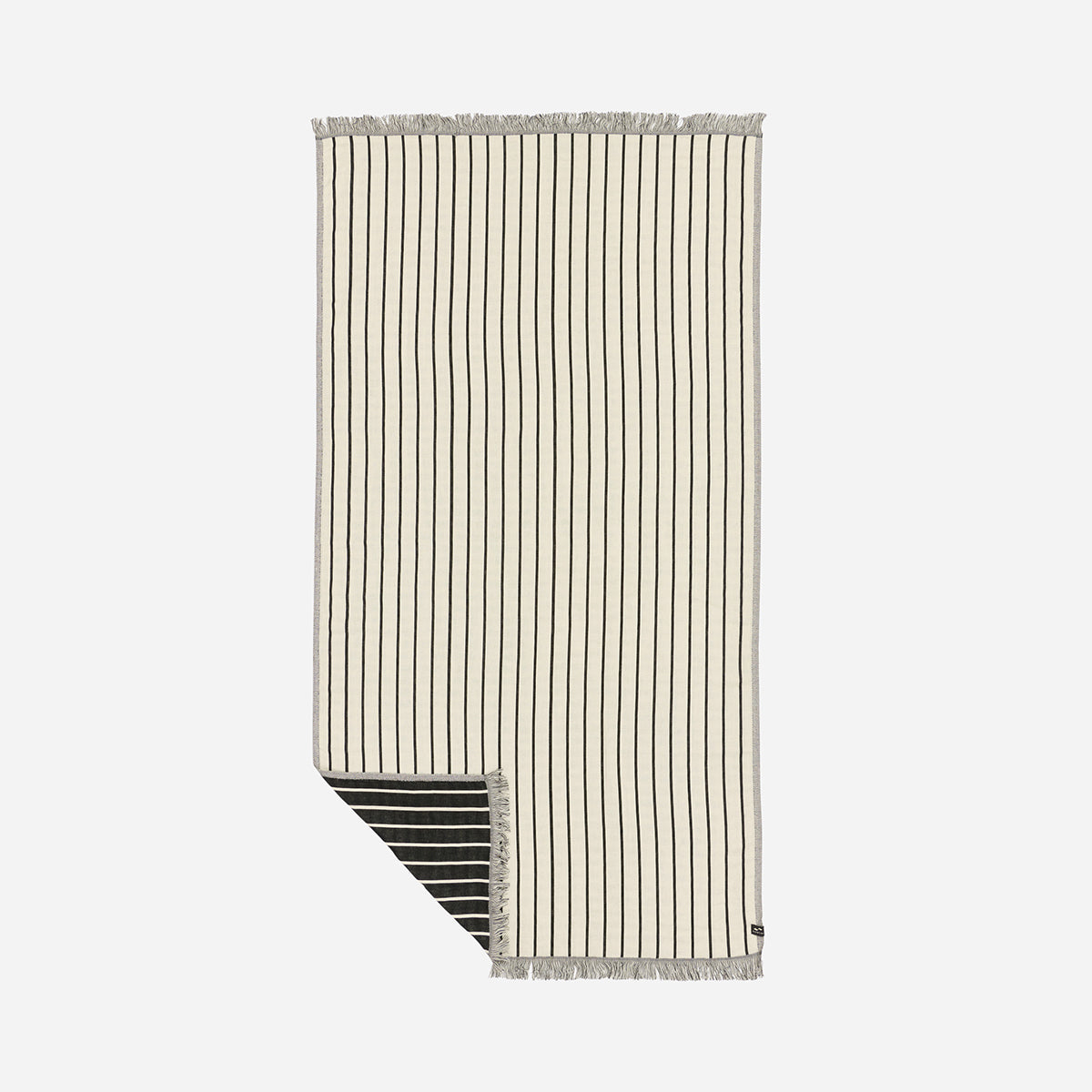 Turkish towel, cream cotton with black stripes and fringed edges, folded corner.