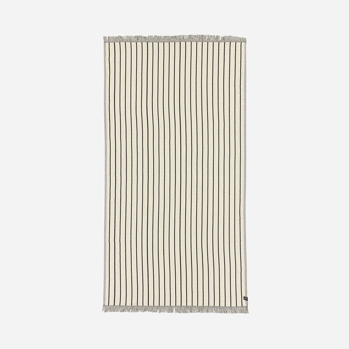 Turkish towel, lightweight beige cotton with thin black stripes and fringe on short ends.