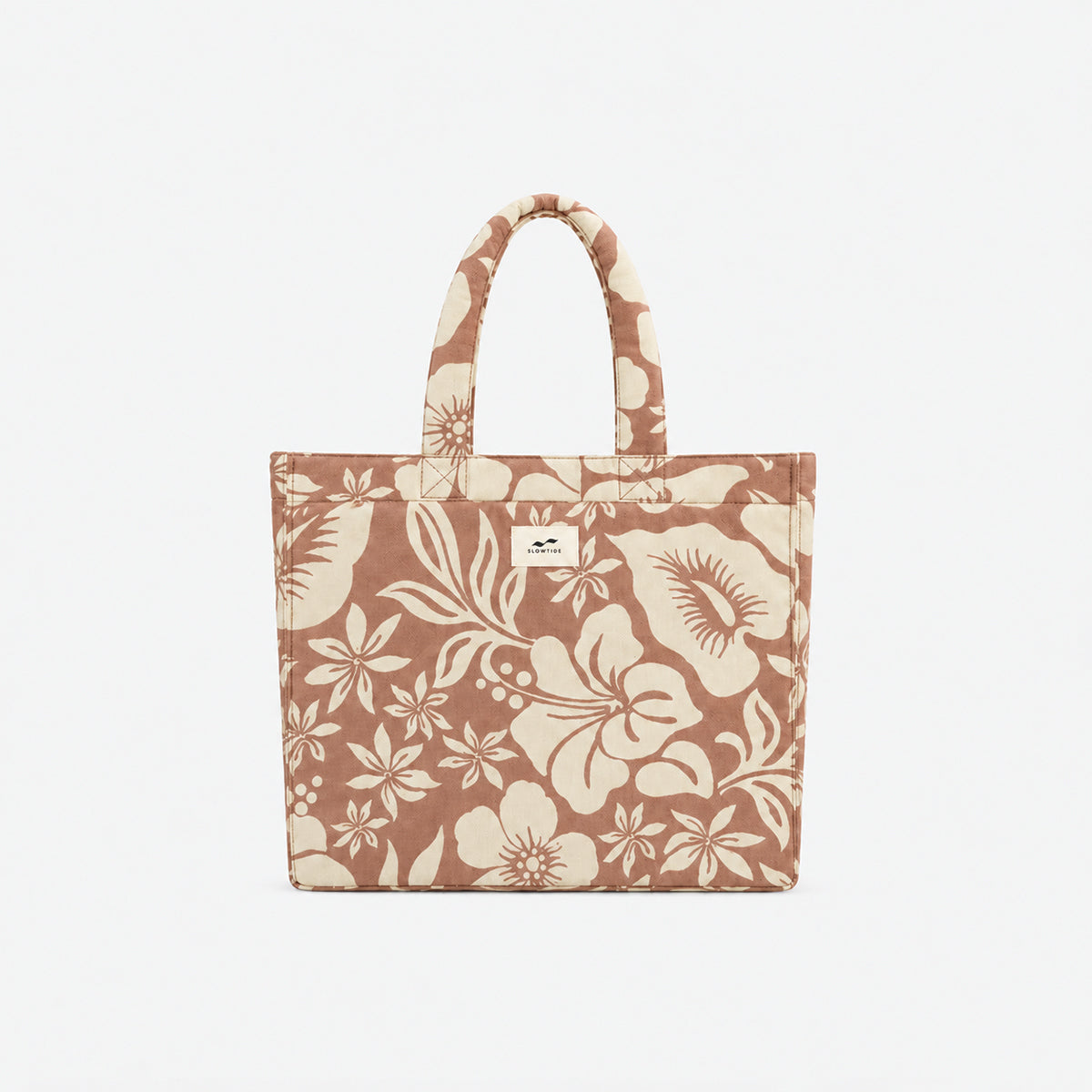 Tote bag in sustainable cotton with beige floral pattern and two handles.