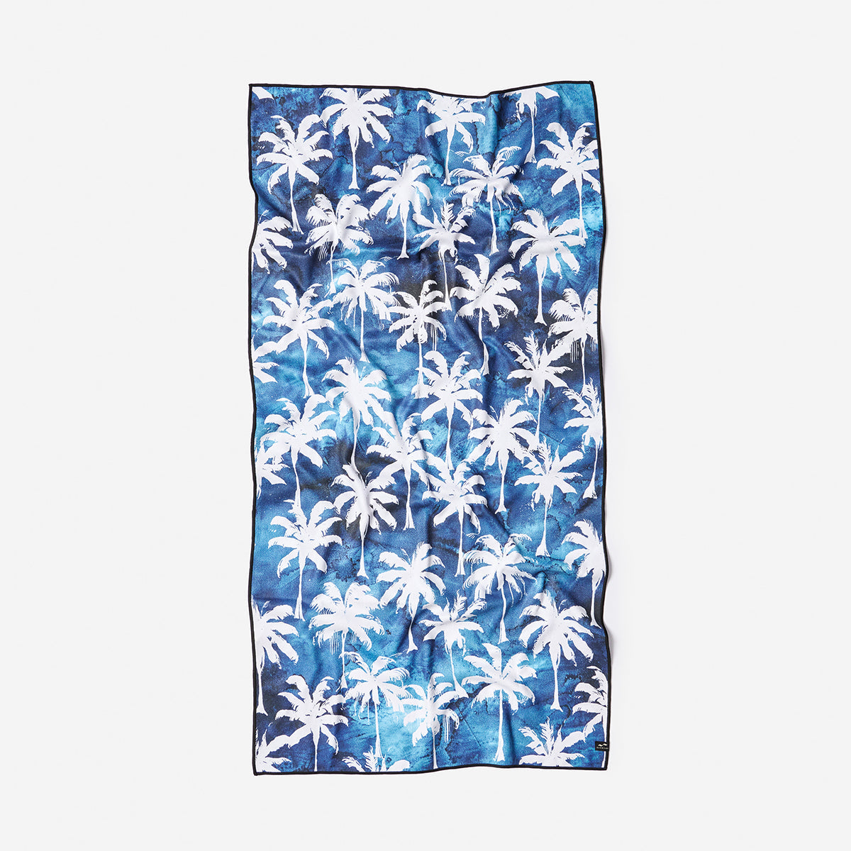 Beach towel, lightweight fabric with white palm tree pattern, slightly wrinkled.