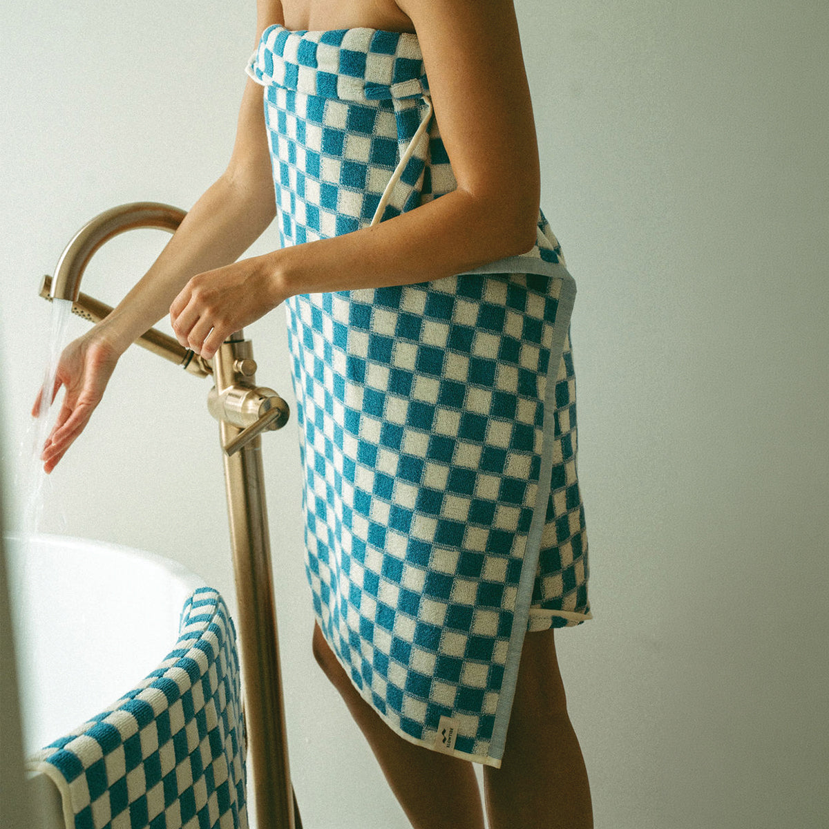 Bath towel wrap in absorbent blue and white checkered cotton.