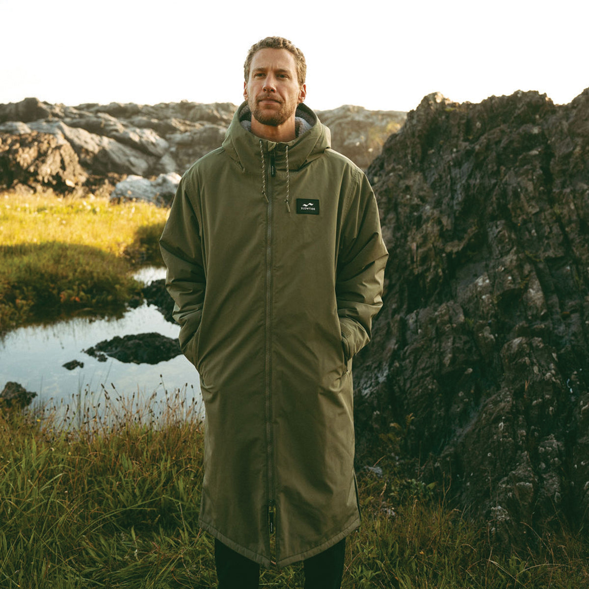 Olive green waterproof insulated longline parka with fleece lining and zipper.