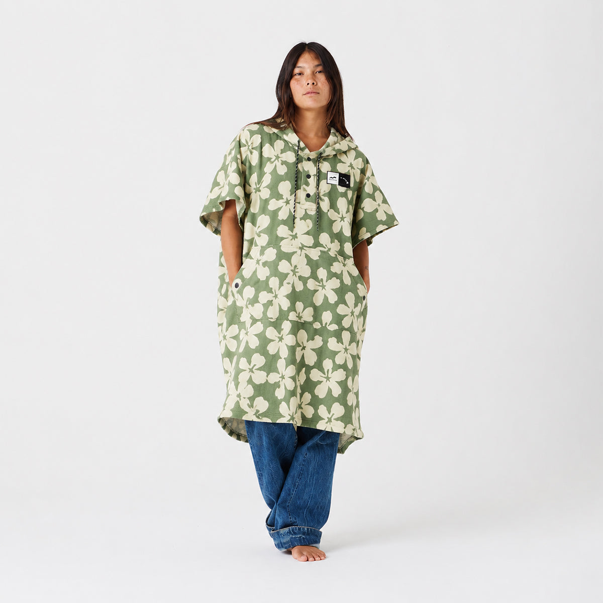Poncho towel in recycled material with green and cream floral print.