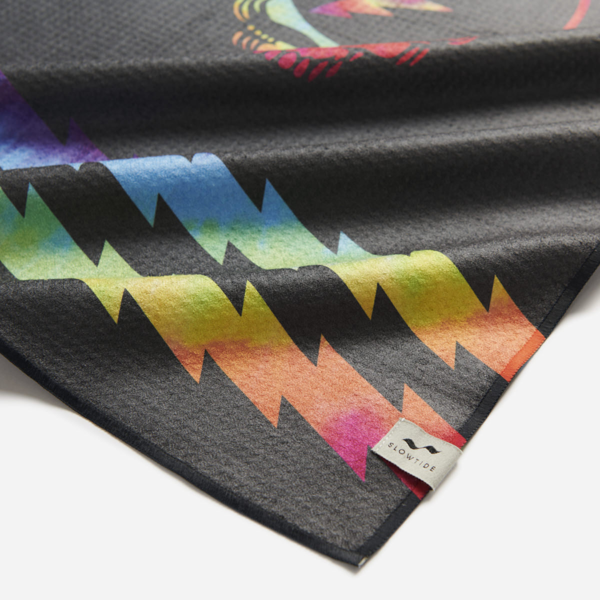 Kitchen towel with rainbow lightning bolt pattern and tag on corner.