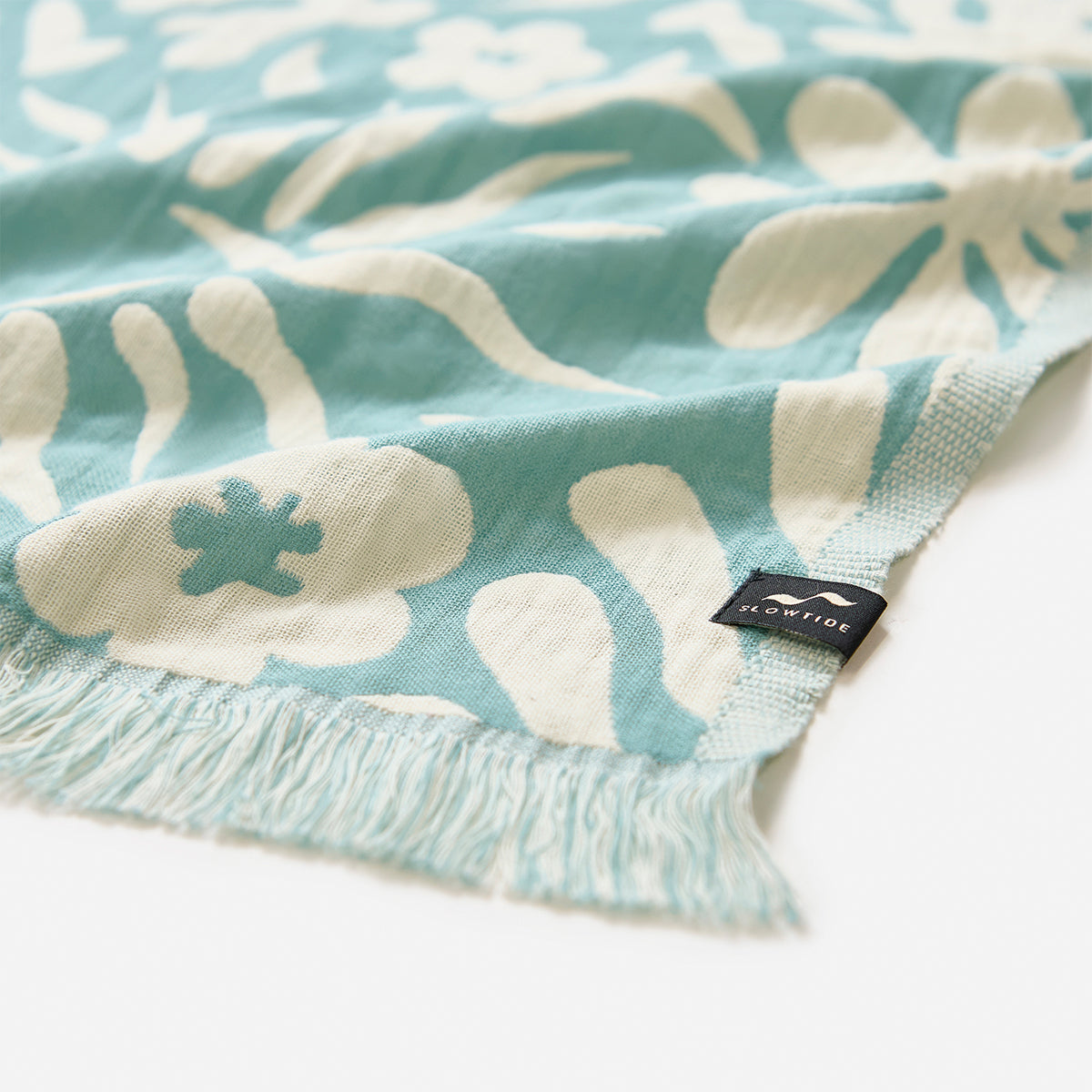 Turkish towel, lightweight cotton, blue and white floral pattern with fringe and small sewn label.