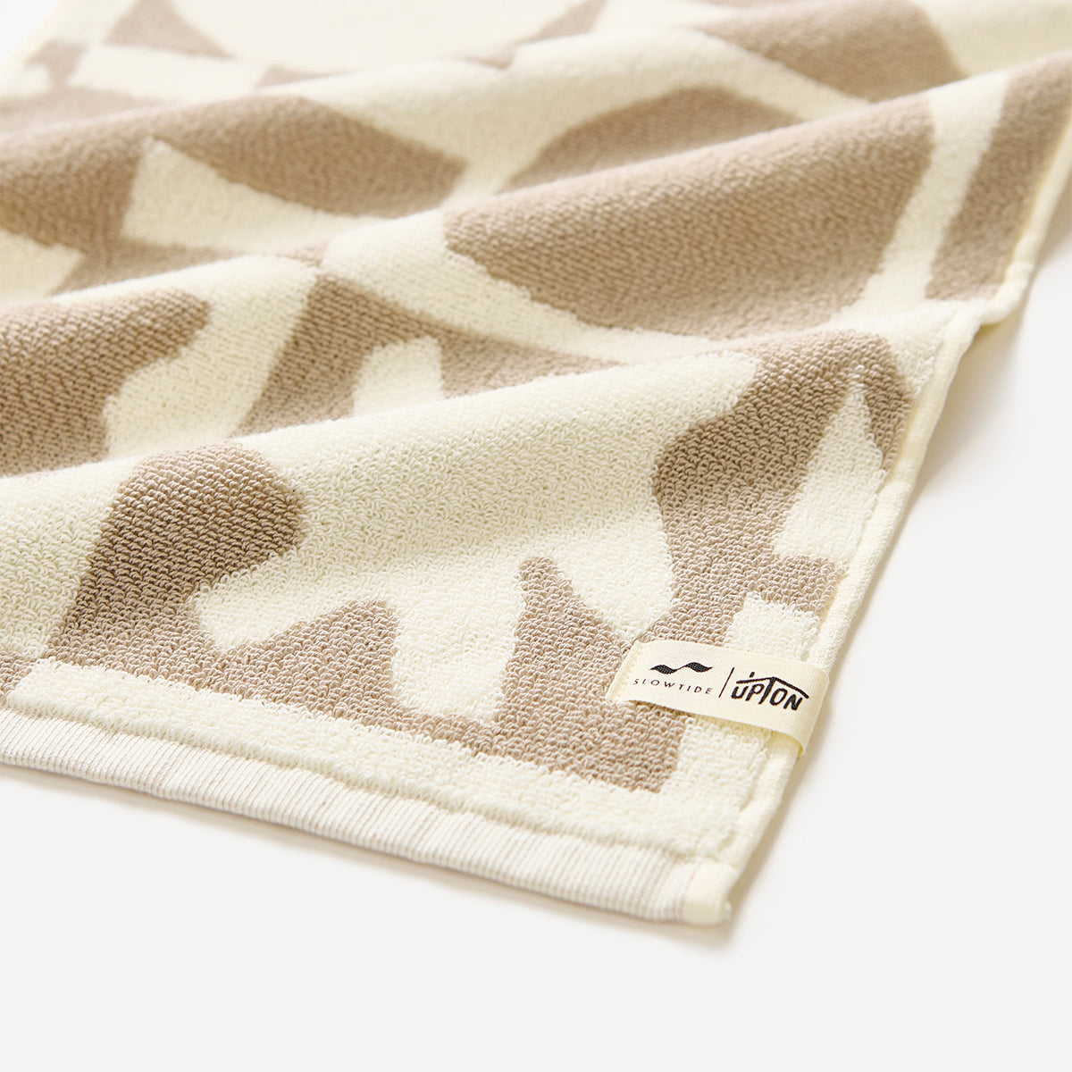 Bath and hand towel bundle, cotton blend, beige and cream geometric pattern on white background.