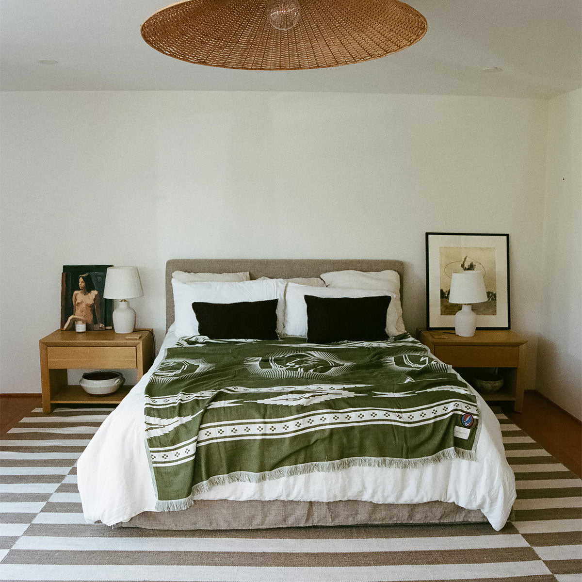 Blanket, green patterned fabric, displayed on a neatly made bed.