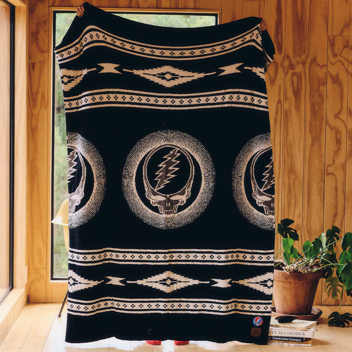 Woven throw blanket with central skull emblem.