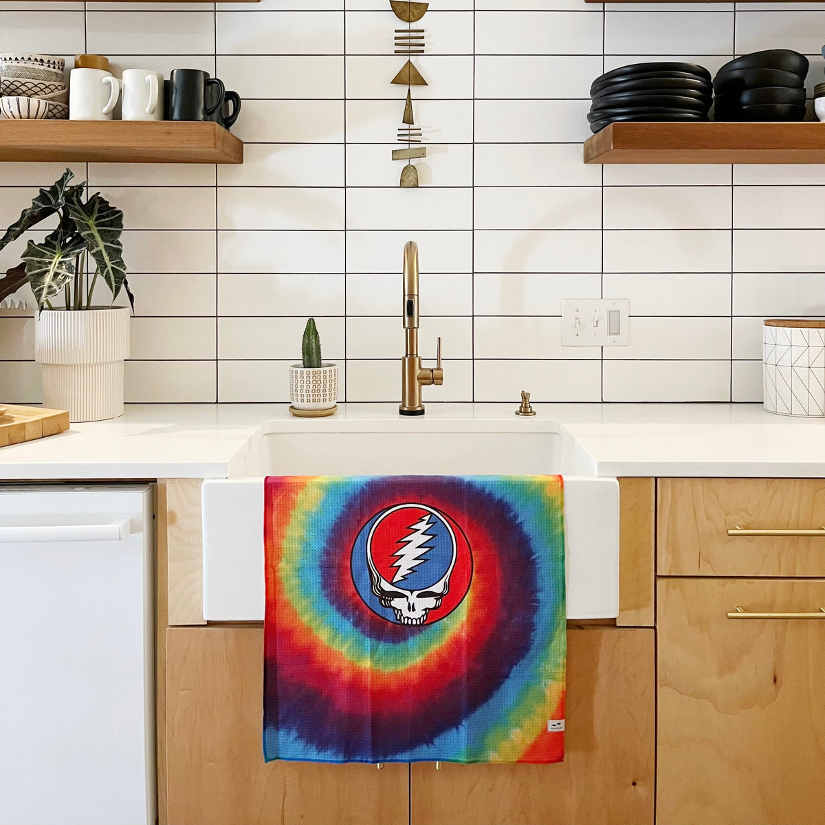 Kitchen towel with skull logo hanging on sink in modern kitchen.