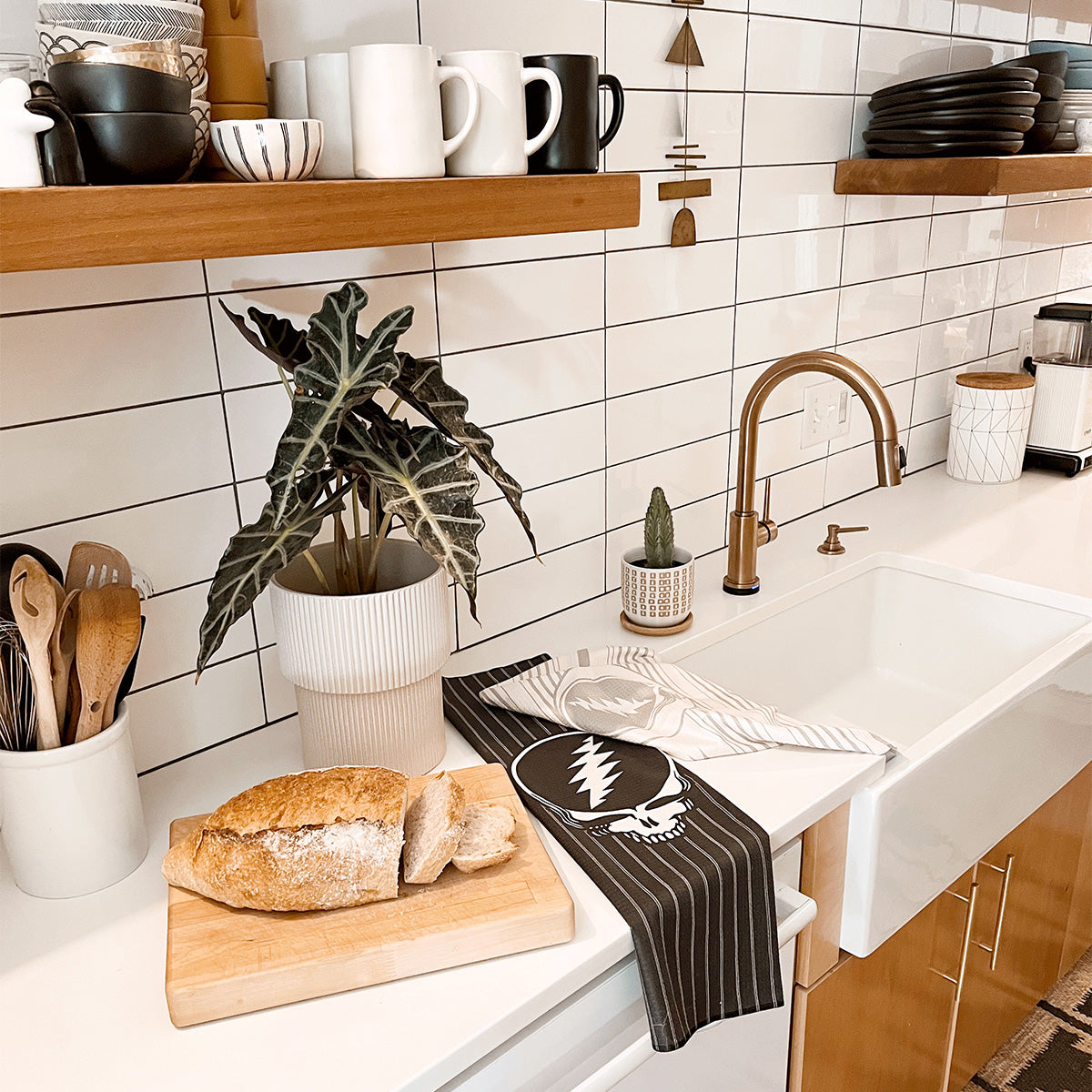 Kitchen towel with colorful graphic print on counter by sink in a modern kitchen.