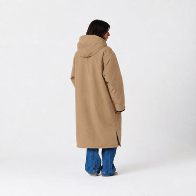 Tan all-weather parka with hood, paired with blue jeans, shown from the back.