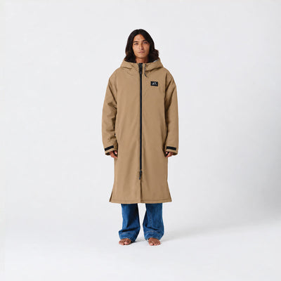 Tan waterproof parka, hip-length, with jeans displayed on plain white background.