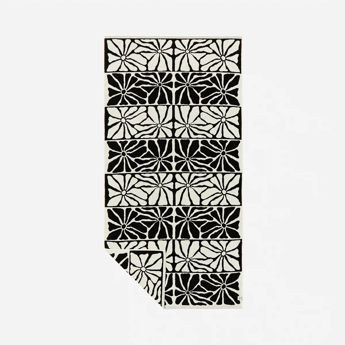 Patterned rug with black and white abstract floral design, sand-resistant style.