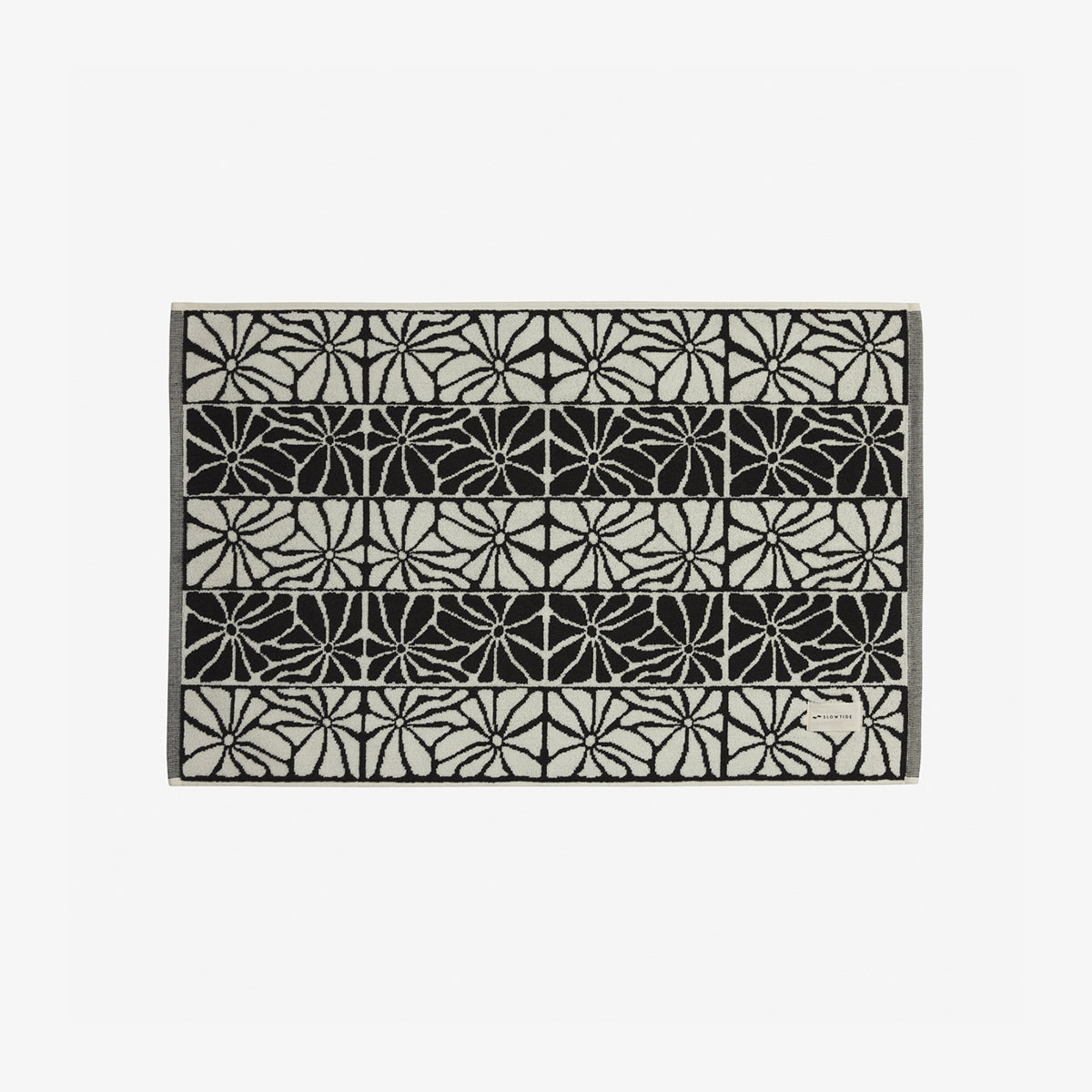 Quick dry towel with black and white geometric floral pattern in horizontal rows.