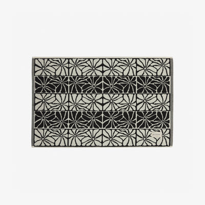 Quick dry towel with black and white geometric floral pattern in horizontal rows.