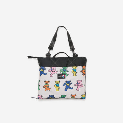 Tote bag with colorful Dancing Bears pattern and black handles on white.