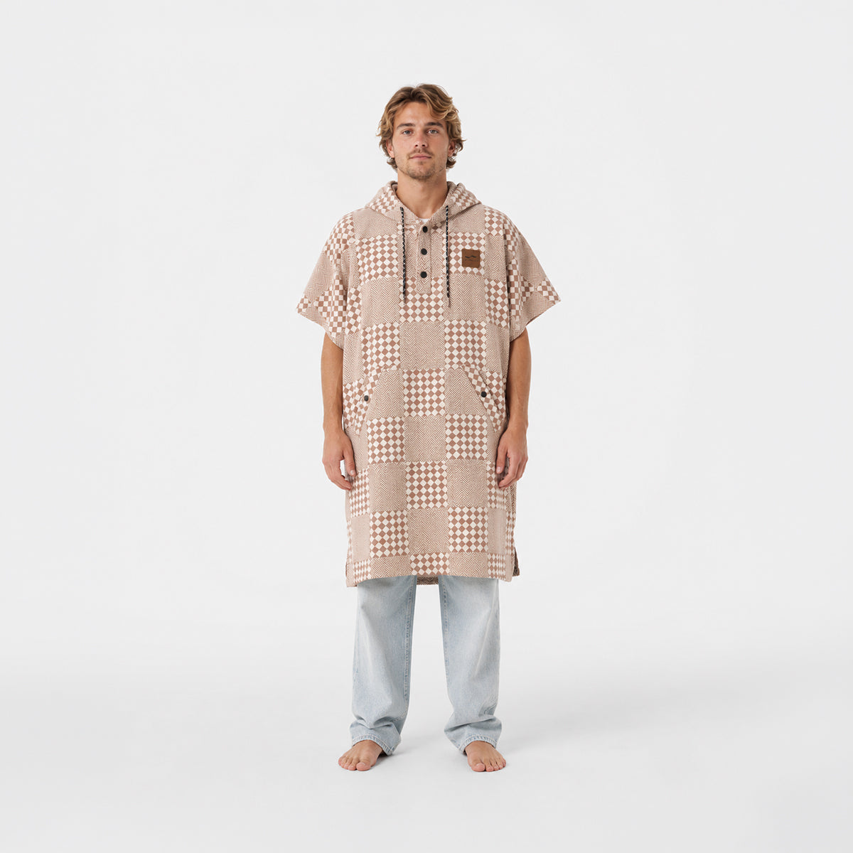 Changing poncho in sustainable cotton with a tan and white checkerboard pattern.