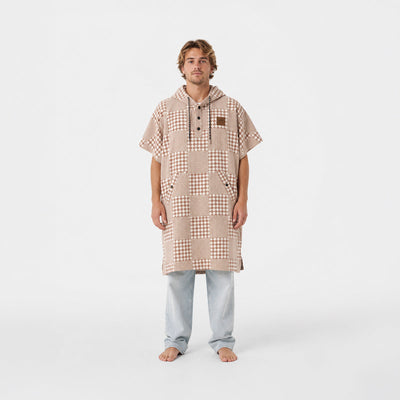 Changing poncho in sustainable cotton with a tan and white checkerboard pattern.