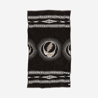 Black plush towel with white geometric and lightning skull pattern, vertical design.