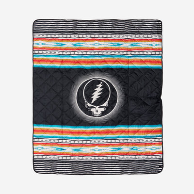 Picnic blanket with colorful stripes and central skull logo.