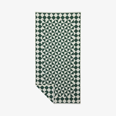 Bath towel with green and white diamond and triangle geometric pattern.