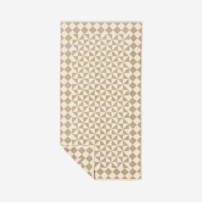 Bath towel in beige and white ultra-soft cotton with geometric pattern on display.