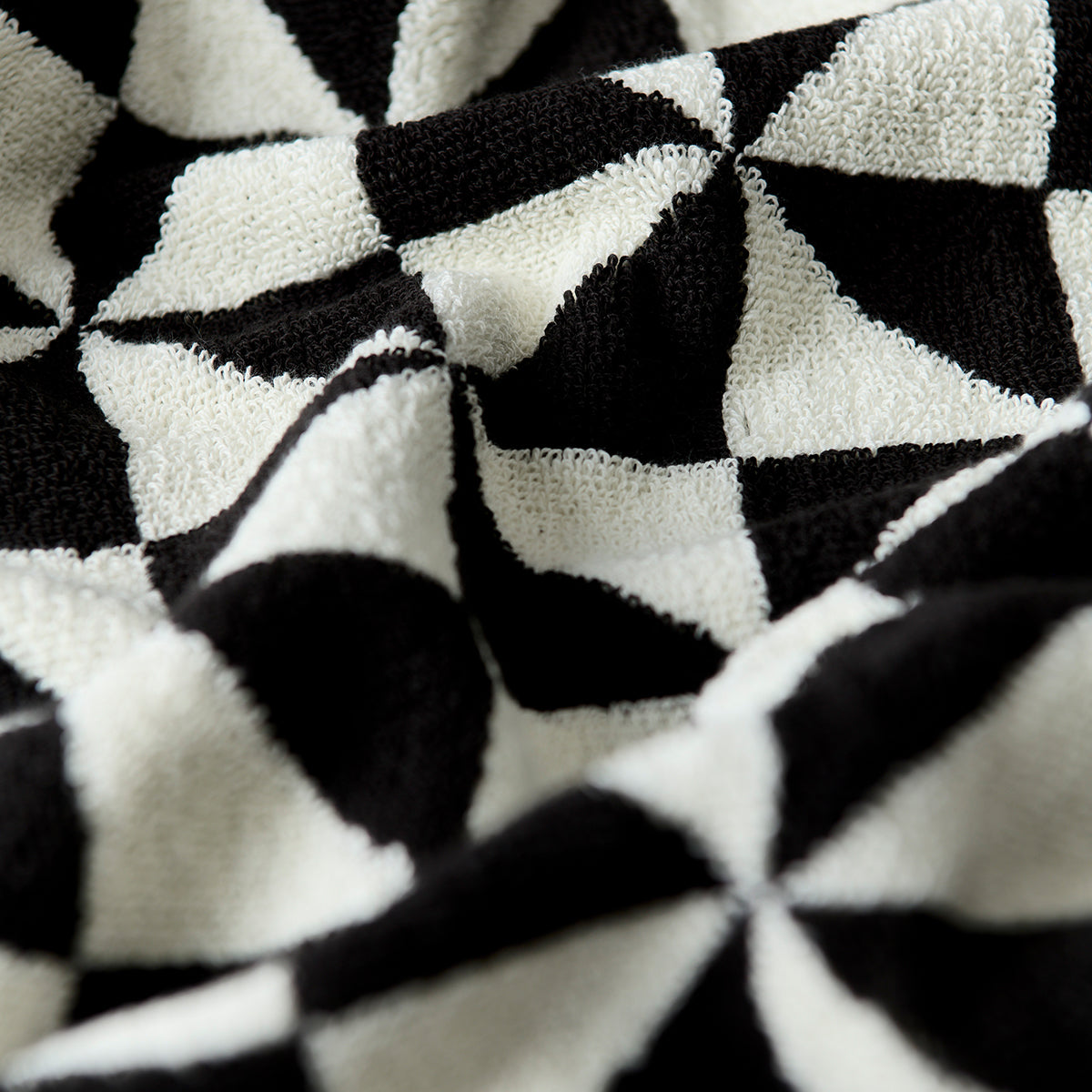 Black cotton bath towel with geometric pattern and textured 600 GSM fabric.