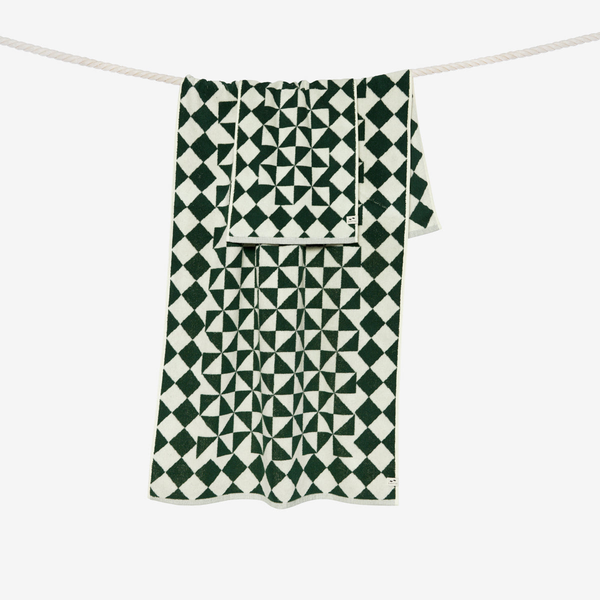Hand towels with black and white geometric patterns hanging on a rope.