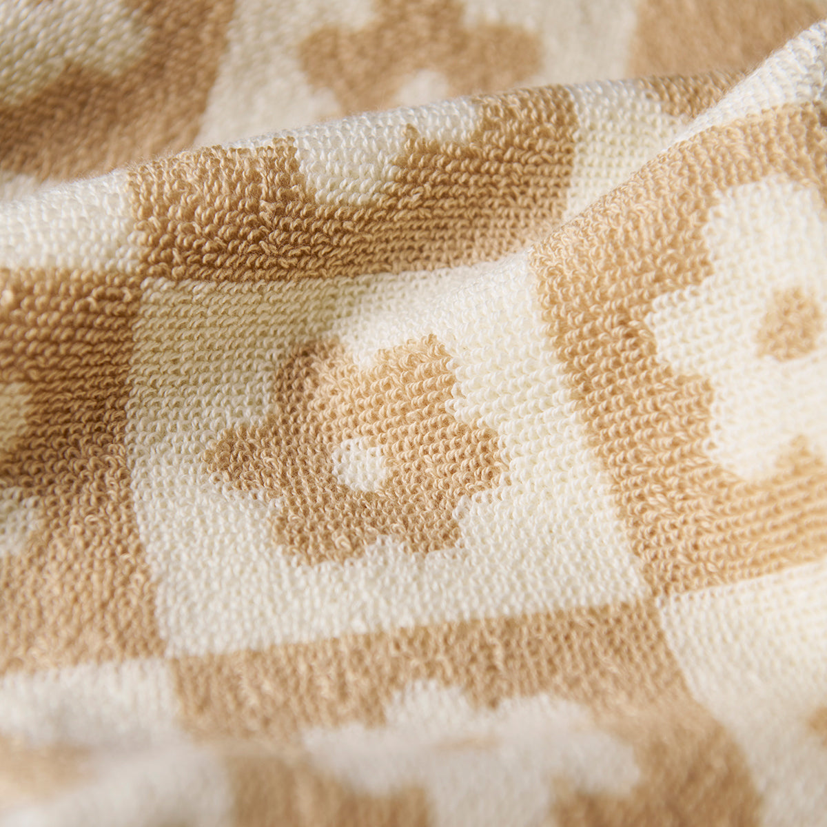Cotton towel with floral checkerboard pattern, sustainably sourced.
