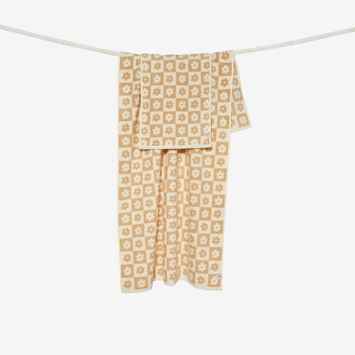 Hand towel, 100 cotton, beige and white floral geometric pattern, hanging on rope.