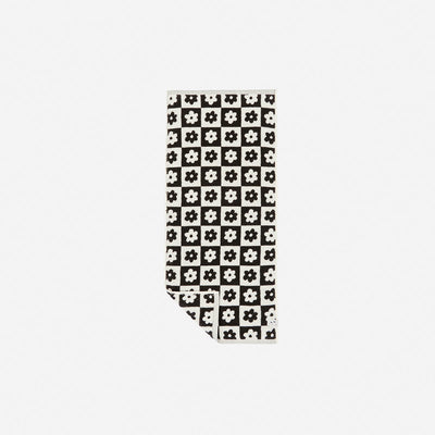 Sand resistant towel with black and white checkered floral pattern.