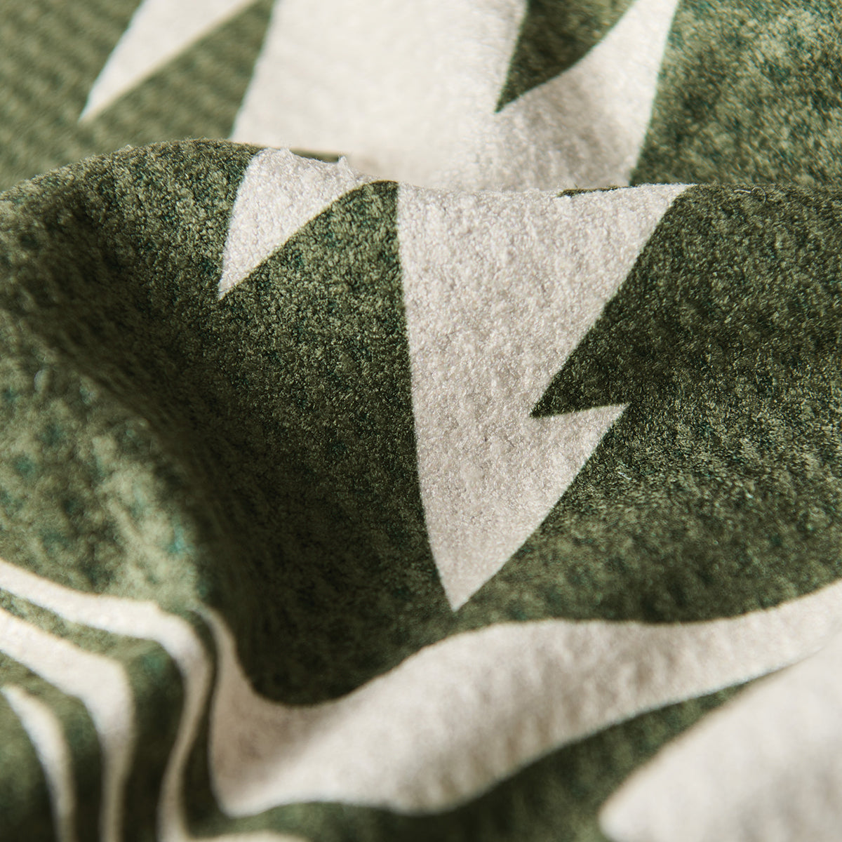 Kitchen towel with green and white abstract pattern, textured fabric, close-up view.