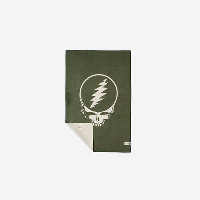 Microfiber towel in green recycled fabric with white skull and lightning bolt graphic, partially folded.