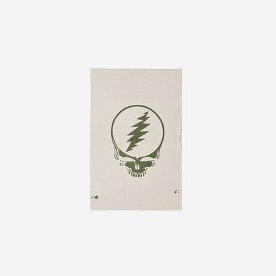 Microfiber towel in beige recycled material with central green skull and lightning bolt graphic.