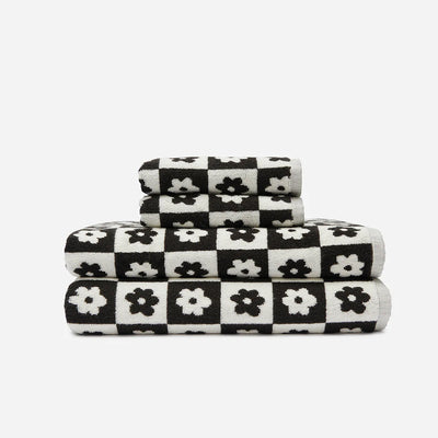 Bath towels, 100 cotton, black and white checkered with floral pattern, stacked.