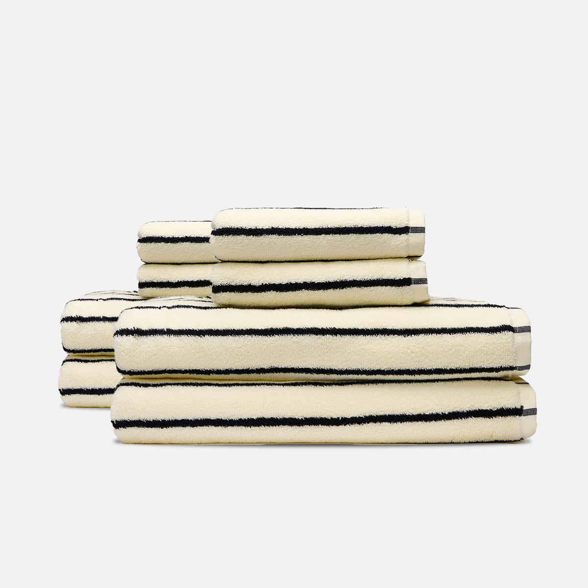 Cotton bath towels in cream with black stripes, stacked.