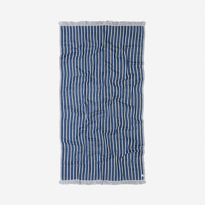 Towel with navy and white pinstripes, fringe edges, laid flat.