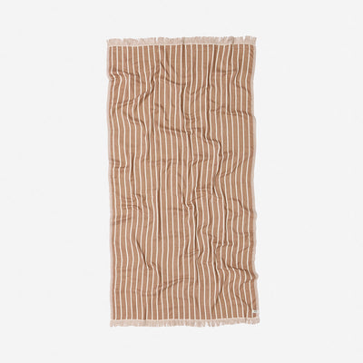 Oversized terracotta towel with white stripes and fringed edges on a plain background.