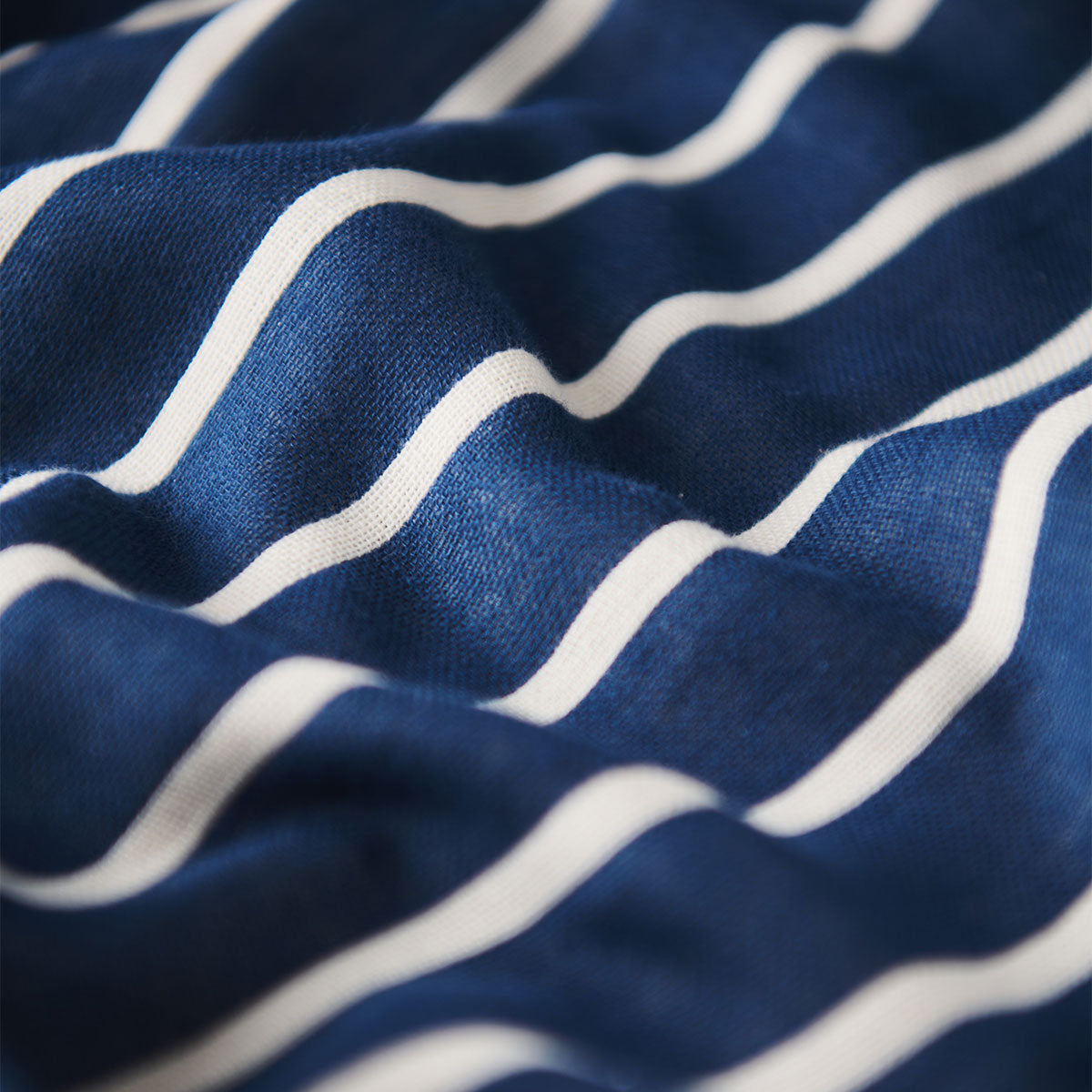 Shirt fabric with nautical blue, navy, and white pinstripes, shown in soft folds.