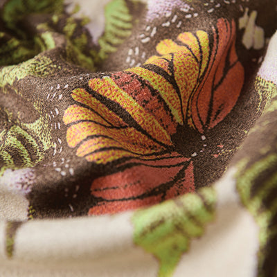 Towel with floral, butterfly, and leaf patterns in orange, yellow, and green colors.
